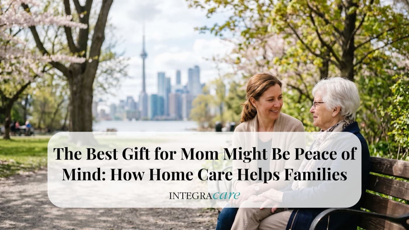Adult daughter sitting with her elderly mother on a park bench with the Toronto skyline in the background, representing peace of mind and compassionate home care support for seniors in Canada.