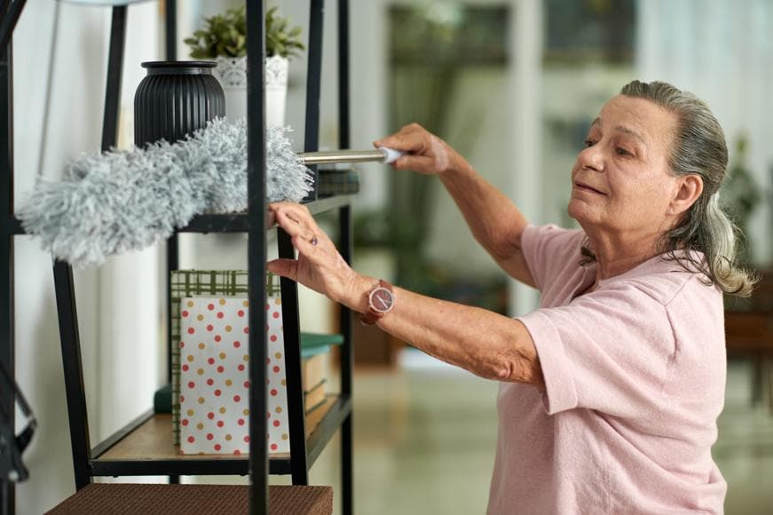 senior woman wiping off dust