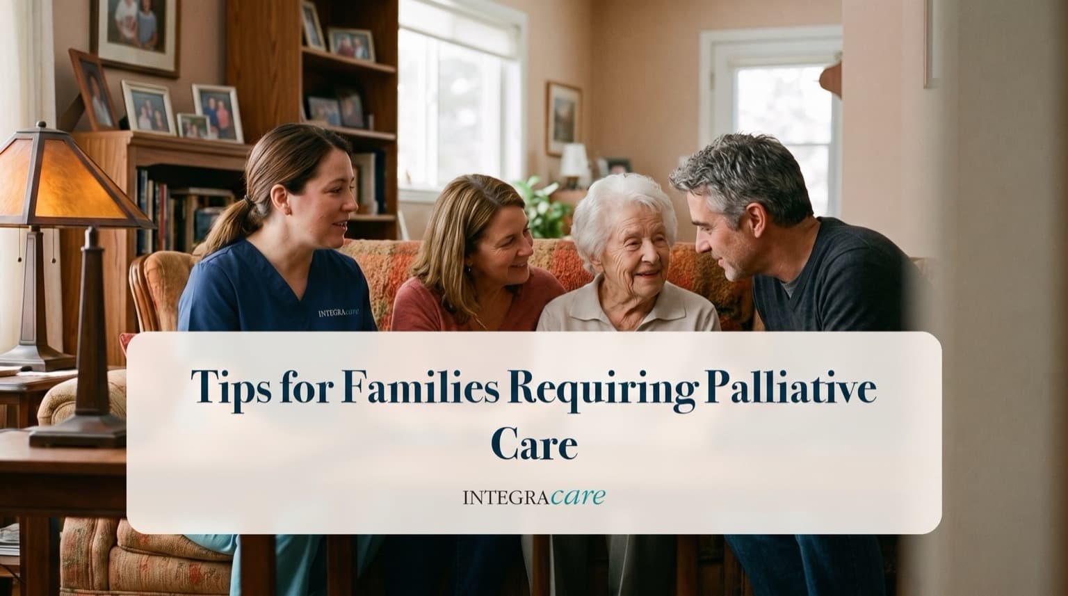 A caregiver and three family members gather around a senior woman on a living room sofa