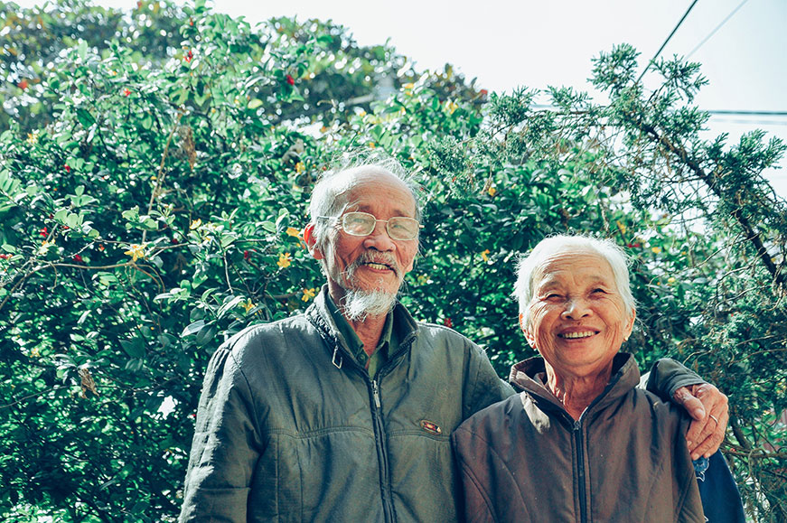An older couple smiling together outdoors