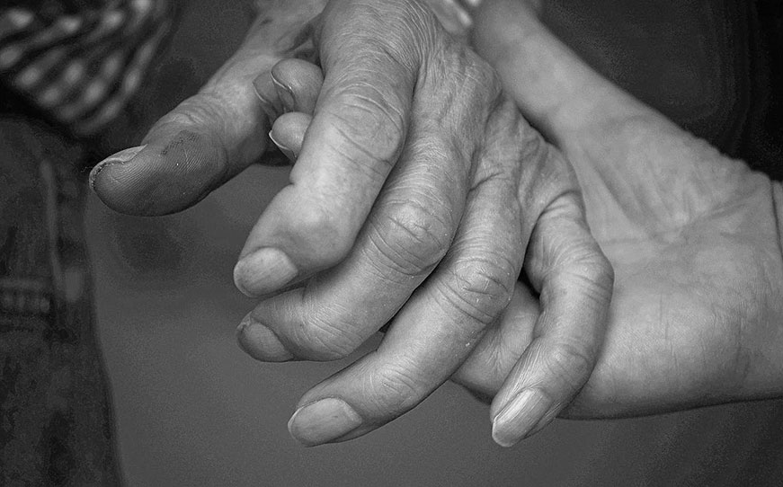 Black and white picture of person holding seniors hand