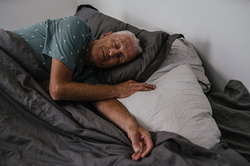 Senior man sleeping in bed