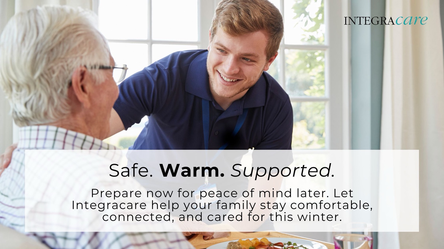 Integracare home caregiver smiling with elderly man over breakfast, promoting safe, warm, and supported home care during the winter season.