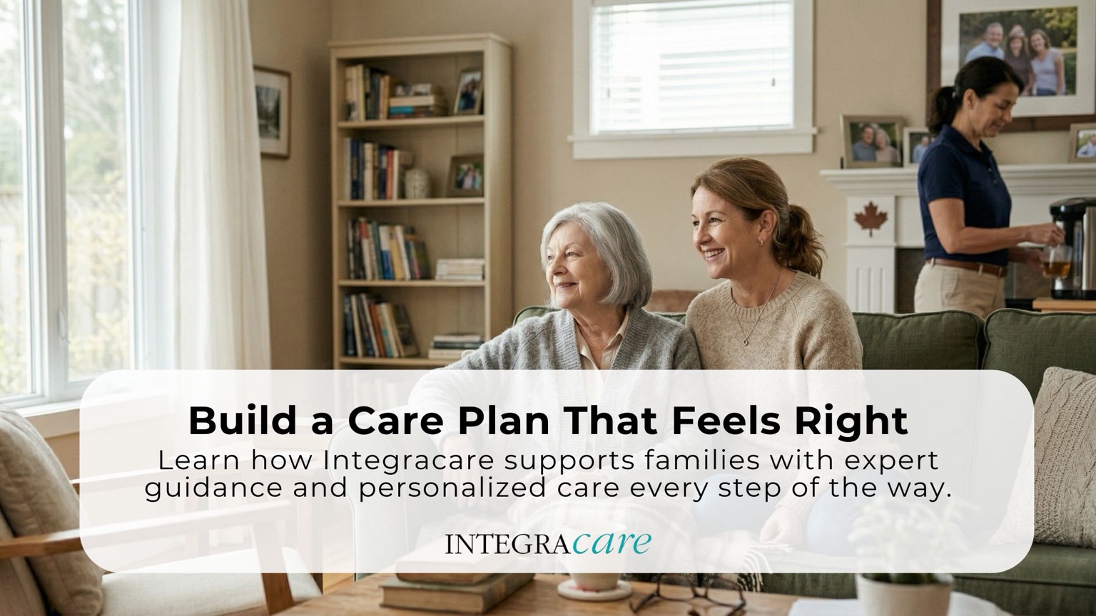 Smiling senior woman and caregiver sitting together in a living room while a professional caregiver prepares tea in the background, representing personalized home care planning and support services by Integracare in Canada.