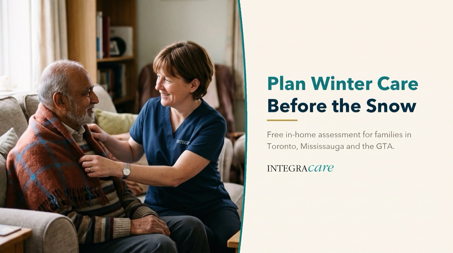 A caregiver in navy scrubs wrapping a warm plaid blanket around a smiling senior man seated on a sofa